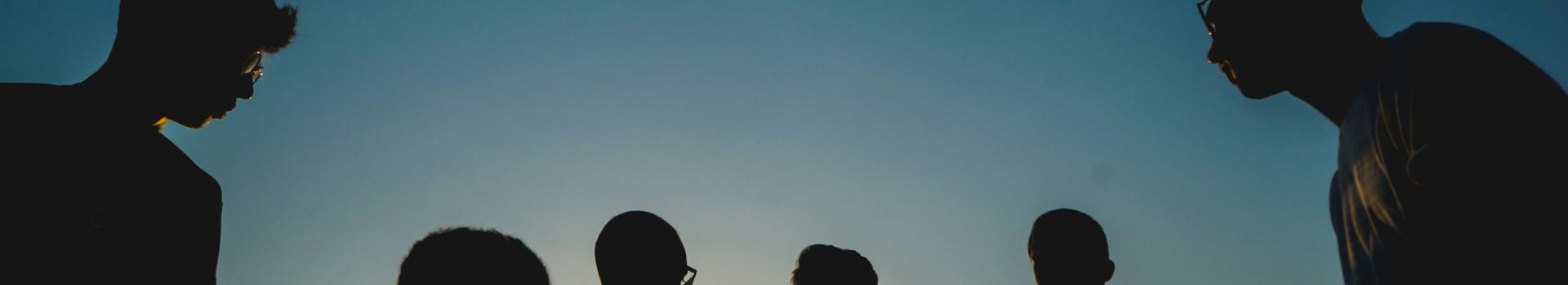 ombres de personnes rassemblées contre l'horizon